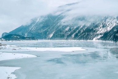 Frozen Lake Louise in winter with mountain backdrop and ice skating scene